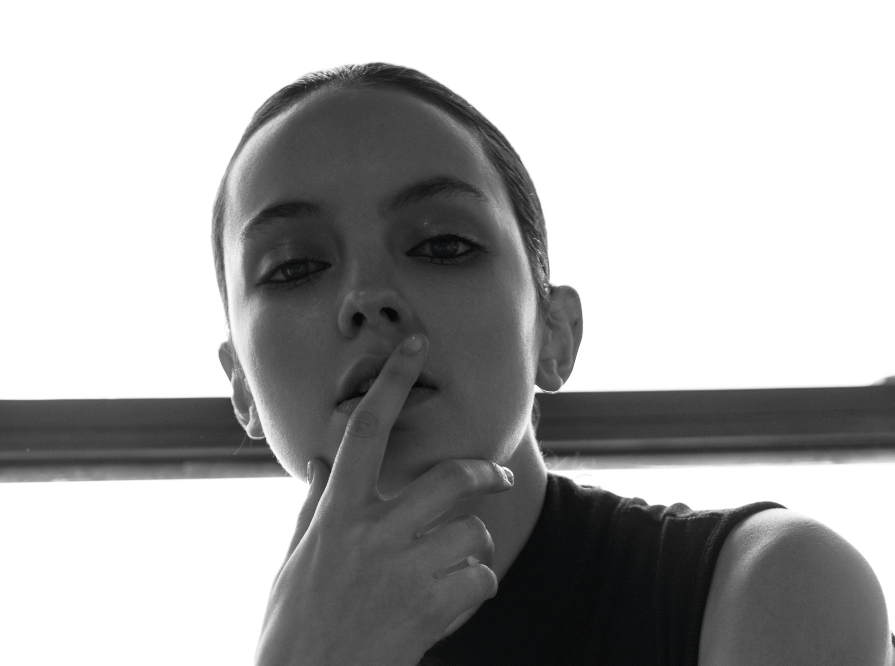 Black and white portrait with a finger resting at the lips